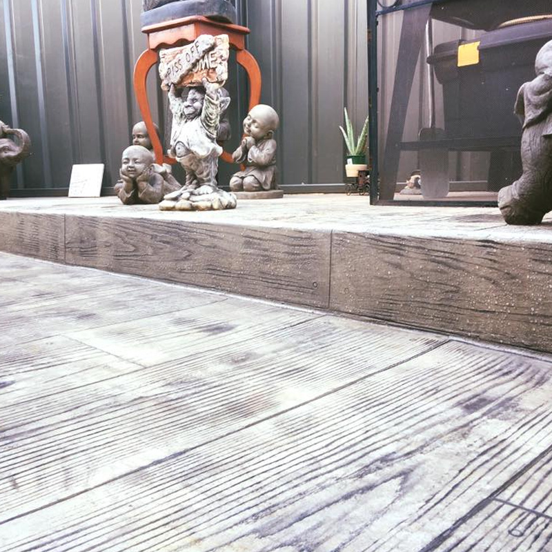 Timber-look stencilled concrete patio with a raised step