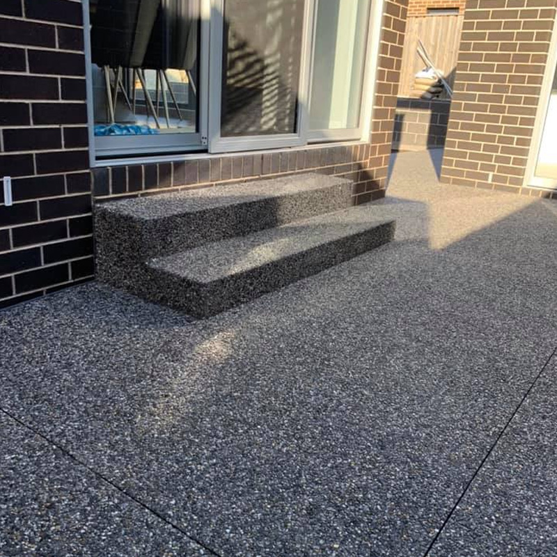 Exposed aggregate courtyard and steps at a back sliding door