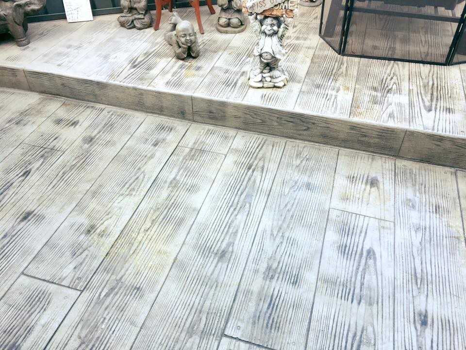 Close-up of a weathered timber-look stencilled concrete patio and step