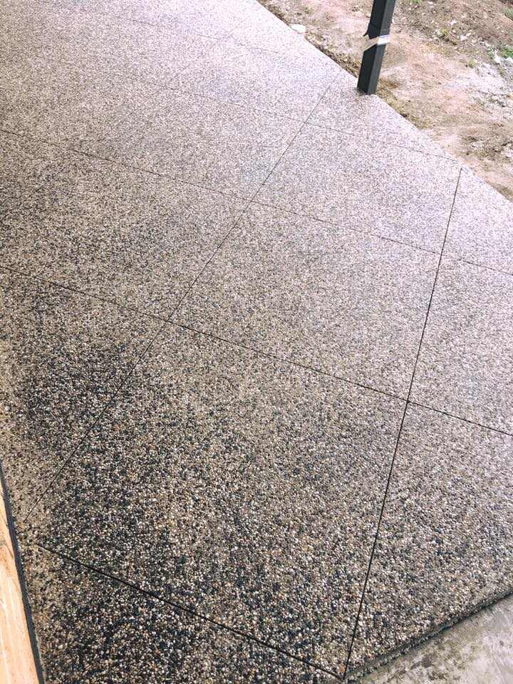 Close-up of exposed aggregate concrete with saw-cut joints