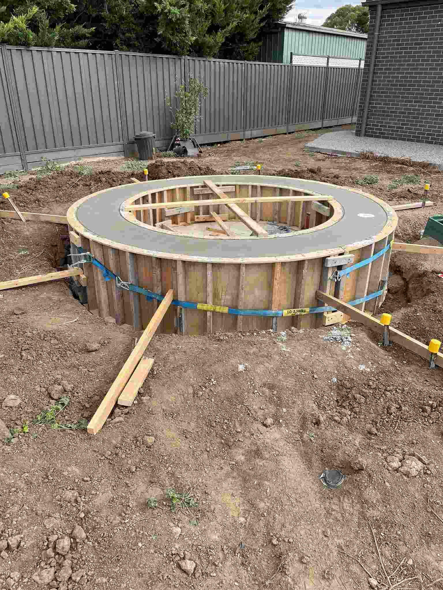 Circular timber formwork set up for a concrete pour in a backyard