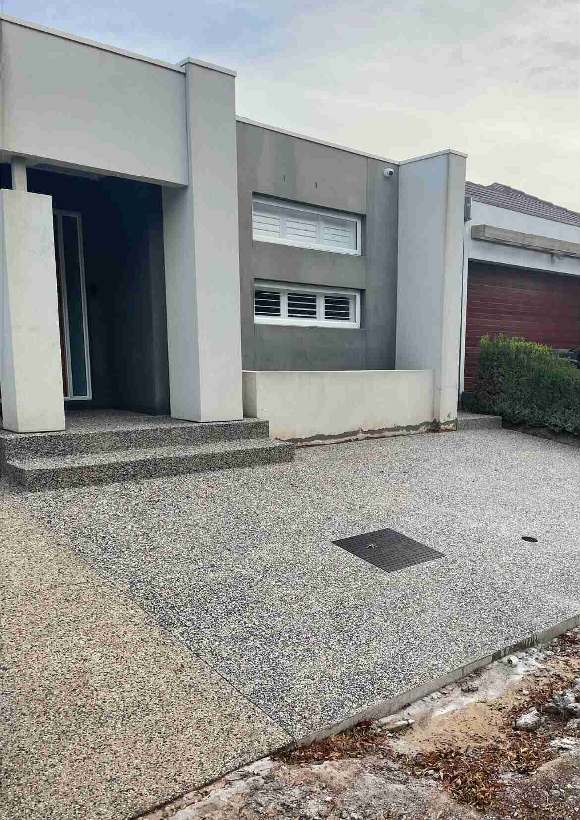 Exposed aggregate driveway and front steps at a modern home