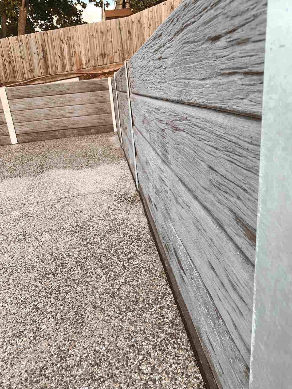 Exposed aggregate path running beside a sleeper retaining wall